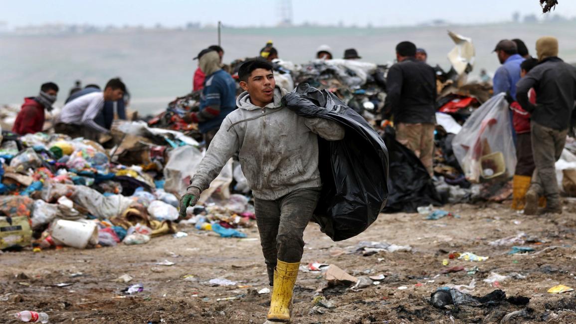 عراقي يبحث في النفايات- فرانس برس