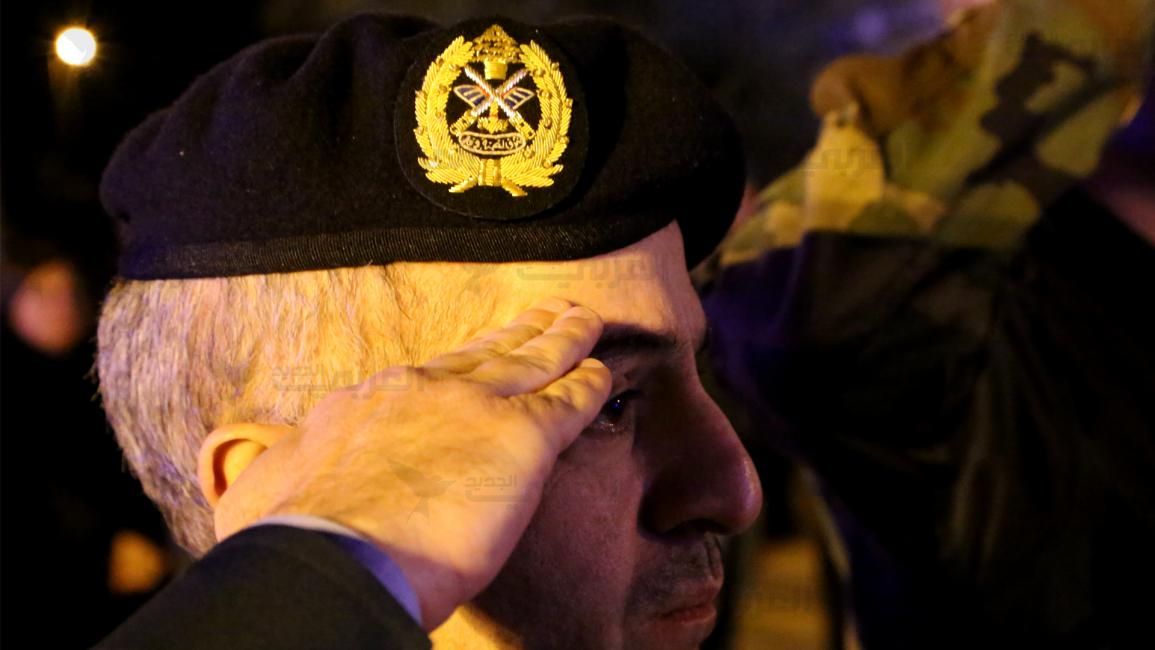 ضابط في القوات الجوية اللبنانية يؤدي التحية لنعوش الضحايا