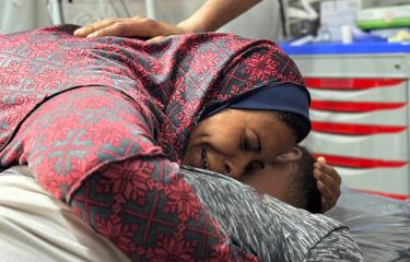 امرأة تبكي بينما تحتضن جثمان زوجها الذي قتل بغارات إسرائيلية على رفح، 10 مايو 2024 (Getty)