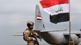 جندي يقف حارسا بينما سلم التحالف الذي تقوده واشنطن إلى العراق قاعدة القيارة الجوية في جنوب الموصل (الأناضول)