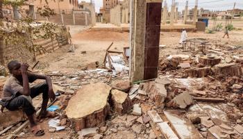 سوداني يجلس وسط منزل تضرر في الحرب في الخرطوم، يونيو الماضي (فرانس برس)