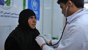 طبيب يعاين امرأة في مخيم الركبان عام 2017 (خليل مزرعاوي/ فرانس برس)