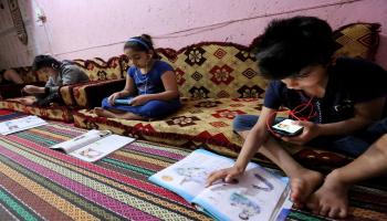 أطفال عراقيون يتابعون دراستهم عن بعد بسبب الحظر (Getty)