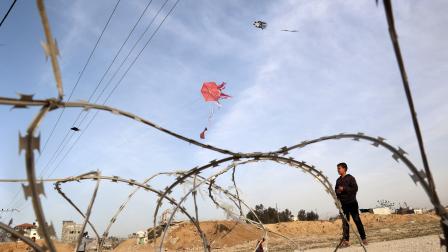 	 أطفال يُطيّرون طائرة ورقية بالقرب من الحدود مع مصر، رفح جنوب قطاع غزة، 28 آذار/ مارس 2024، (Getty)