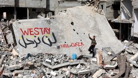 عبارتا لن نرحل وغزة حرة على أنقاض الأبنية في بيت لاهيا (عمر القطا/الأناضول)