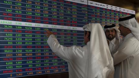 متعاملون في البورصة القطرية بالدوحة يراقبون أداء الأسهم (getty)