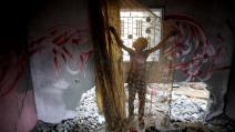 صبي فلسطيني يقف أمام جدارية في منزل دمره الاحتلال، 23 حزيران/ يونيو، 2023 (Getty)