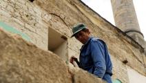(عامل يشارك في ترميم مسجد في بريشتينا عام 2012، Getty)