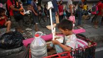 يلعب في انتظار الطعام في الفيليبين (تيد ألجيبي/ فرانس برس)
