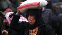 A Syrian woman carries a sac of food on her head at an open market in the northern town of Manbij on the Turkish border, which is controlled since 2016 by an alliance of Kurdish and Arab fighters backed by the US-led coalition, on December 30, 2018. - Syria's Kurds, who have asked for regime help to face a threatened Turkish offensive, have seen their prospects of increased autonomy change over the course of the war. (Photo by Delil SOULEIMAN / AFP) (Photo credit should read DELIL SOULEIMAN/AFP via Getty Im
