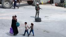 امرأة سورية وأطفالها في درعا (لؤي بشارة/ فرانس برس)