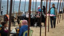 فلسطينيون في مقهى على شاطئ غزة (مجدي فتحي/ Getty)