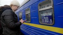 أوكرانيّة تتفحص هاتفها بينما يغادر قطار إجلاء من أوديسا (يوري زوزوليا/يوكرينفورم/نورفوتو)