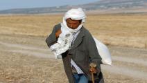 مزارع تونسي يحمل كيساً من القمح (فرانس برس)