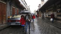 تلاميذ سوريون في دمشق وسط المطر (لؤي بشارة/ فرانس برس)