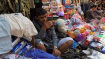 بائع يتصفح هاتفه في سوق بالمدينة القديمة للعاصمة صنعاء/فرانس برس