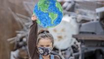 طفلة تحتج أمام نفايات تلوث البيئة في كندا (Getty)