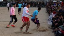 مجموعة من الفلسطينيين يلعبون كرة القدم جنوب قطاع غزة