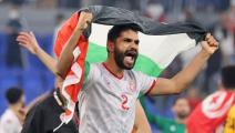التونسي بلال العيفة يحتفل رفقة العلم الفلسطيني (كريم صاحب/فرانس برس)