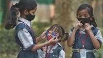 أطفال وكمامات للحماية من تلوث الهواء (سونو مهتا/ Getty)