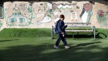 طفلة أمام جدارية لرموز فلسطينية منها العلم (سعيد قاق/Getty)