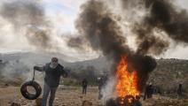 متظاهرون فلسطينيون يحرقون الإطارات خلال مظاهرة في قرية بيتا جنوبي نابلس (جعفر اشتية/فرانس برس)