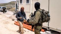 جندي إسرائيلي يحرس مستوطناً في "حوميش"، مايو الماضي (مناحيم كهانا/فرانس برس)