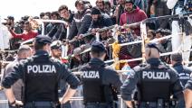 مهاجرون وشرطة إيطالية في إيطاليا (فابريزيو فيلا/ فرانس برس)