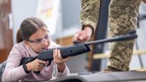 تتعلم استخدام السلاح في أوكرانيا (ستانيسلاف إيفانوف/ Getty)