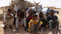 يحاولون الاحتماء من اللهيب على الحدود التونسية الليبية (محمود تركية/ فرانس برس)
