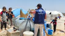فريق ملهم التطوعي يوزع المياه في دير حسان (فيسبوك)