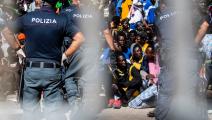 مهاجرون غير نظاميين وشرطة في إيطاليا (أليساندرو سيرانو/ فرانس برس)