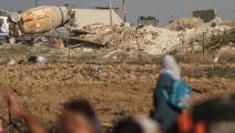 شاحنة إسرائيلية ونازحات ونازحون في قطاع غزة (مصطفى حسونة/ الأناضول)