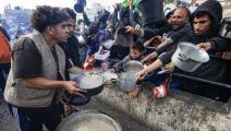 فلسطينيون وتوزيع طعام وسط الحرب على غزة (محمود الهمص/ فرانس برس)