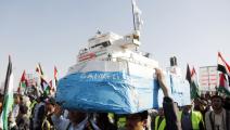 متظاهر يمني يحمل نموذج لسفينة الشحن الإسرائيلية جالاكسي ليدر التي احتجزها الحوثيين (محمد حمود/Getty)