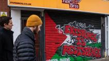 رسم علم فلسطين وشعار "الوجود مقاومة" على أحد متاجر في لندن (مارك كيريسون/Getty)