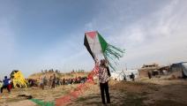 فتاة تمسك بطائرة شراعية عليها علم فلسطين، خانيونس، 28 آذار/ مارس 2024 (Getty)