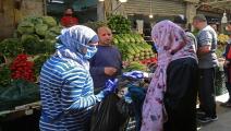 أردنية تضع الكمامة أثناء شراء الخضراوات في عمان (Getty)