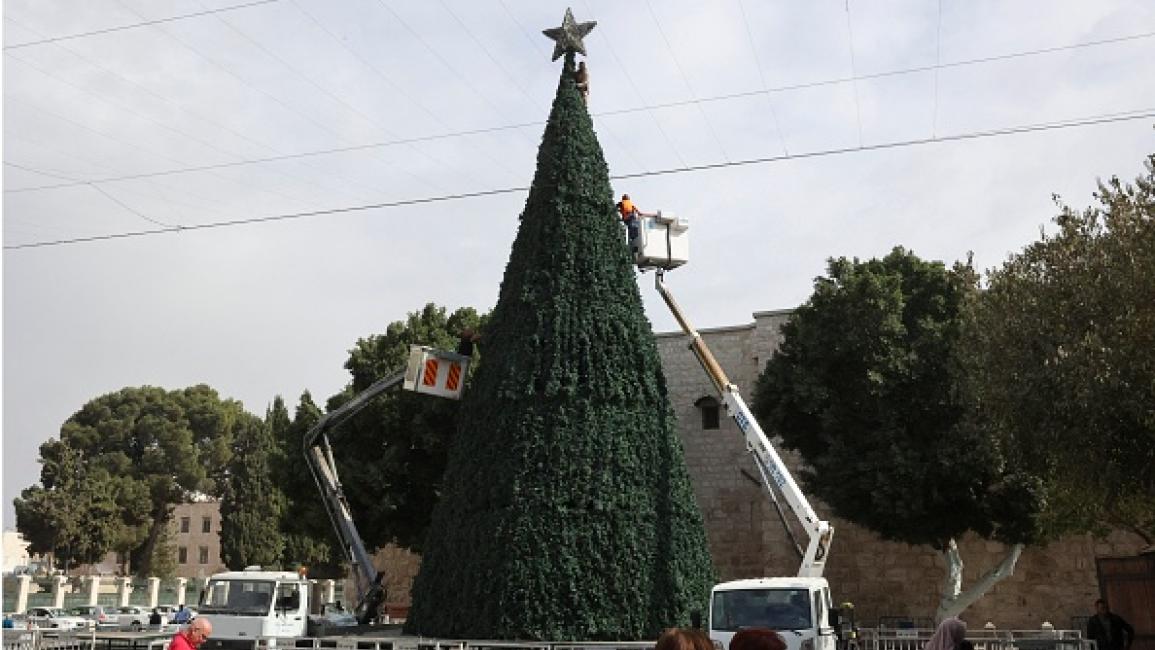 عمال البلدية الفلسطينية يصلحون شجرة عيد الميلاد (حازم بادر/Getty)