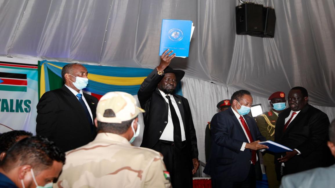 رئيس جنوب السودان سلفا كير يرفع وثيقة التوقيع بين الحكومة الانتقالية والجبهة الثورية في جوبا في 31/ 8/ 2020 (فرانس برس)