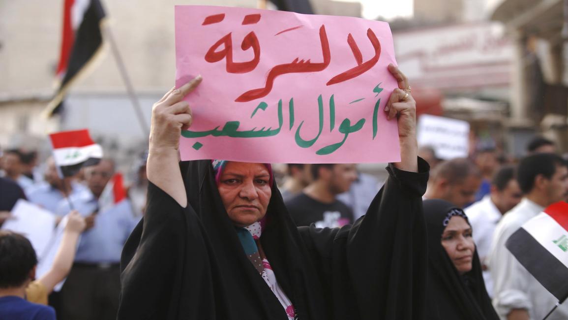 امرأة عراقية تحمل لافتة خلال مظاهرة ضد الفساد وسوء الخدمات في مدينة كربلاء في 6 / 8/ 2015 (فرانس برس)