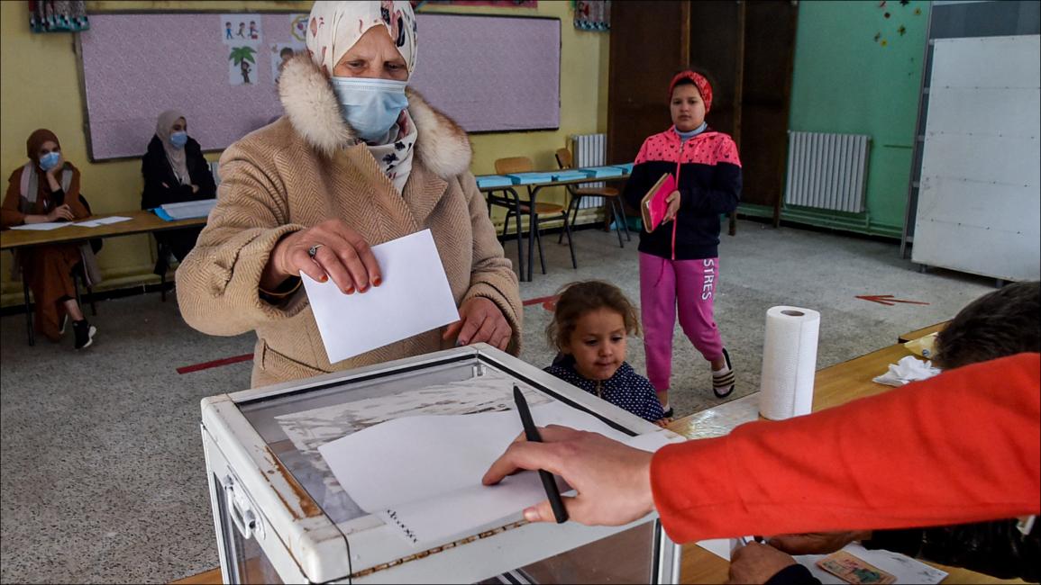 امرأة تدلي بصوتها أثناء التصويت في الانتخابات المحلية الجزائرية في مركز اقتراع بالعاصمة الجزائر (رياض كرامدي/فرانس برس)