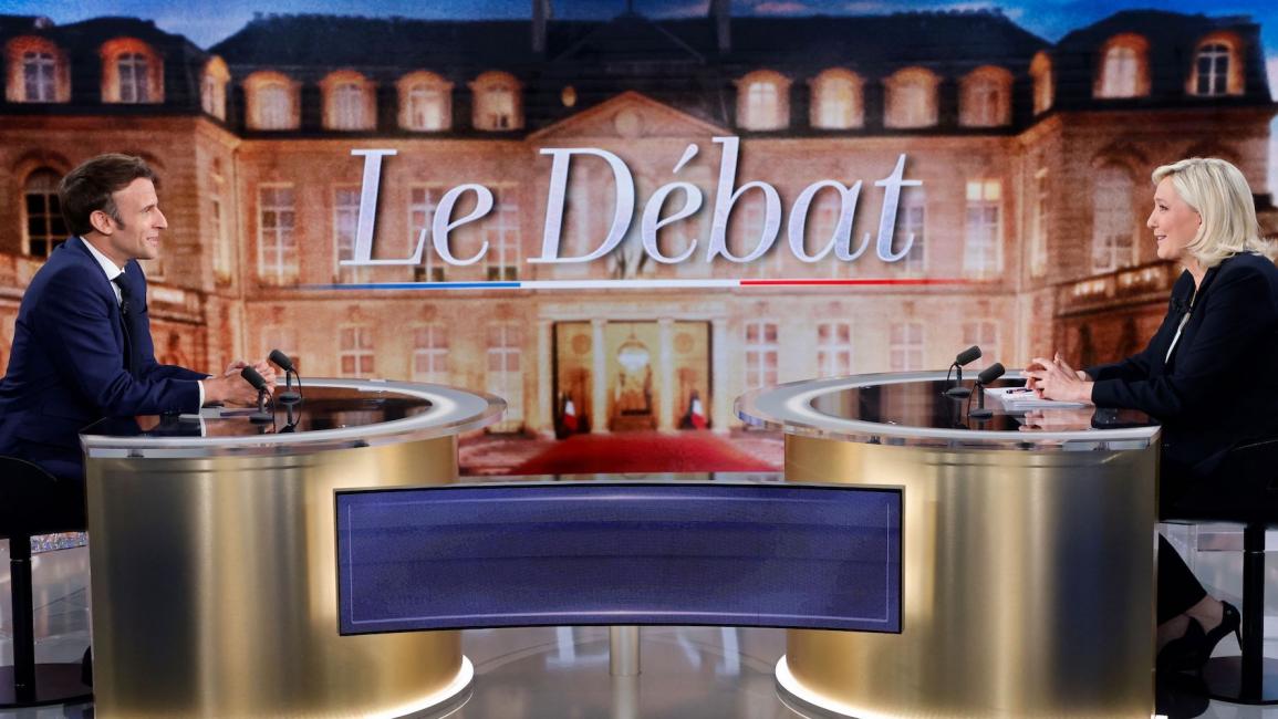 إيمانويل ماكرون ومارين لوبان خلال مناظرة تلفزيونية قبل الجولة الثانية من الانتخابات الفرنسية في باريس في 20/ 4/ 2022 (فرانس برس)