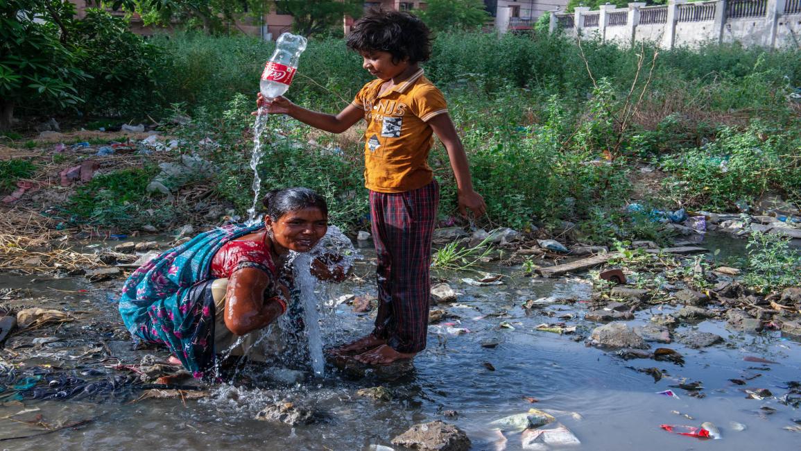 يجمع أطفال الأحياء الفقيرة مياه الشرب من تسرّب أنابيب المياه في مدينة غازي آباد شرق العاصمة دلهي في 12/6/2022 (Getty)