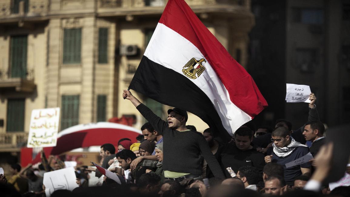 متظاهرون مصريون يلوحون بعلمهم الوطني في ميدان التحرير وسط القاهرة في 30/1/2011 (فرانس برس)