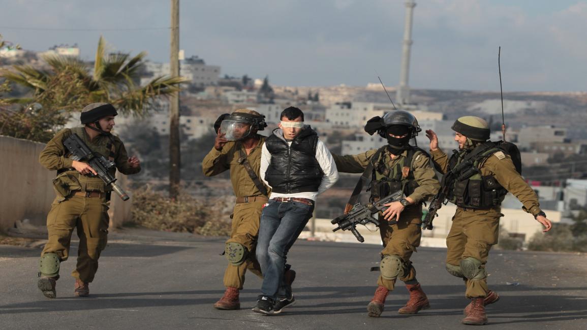جنود الاحتلال يعتقلون فلسطينياً بقرية سلواد بالضفة(عباس مومني/فرانس برس)