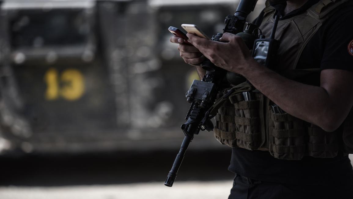 العسكريون أيضا منشغلون بالهواتف في العراق (محمد الشاهد/فرانس برس)