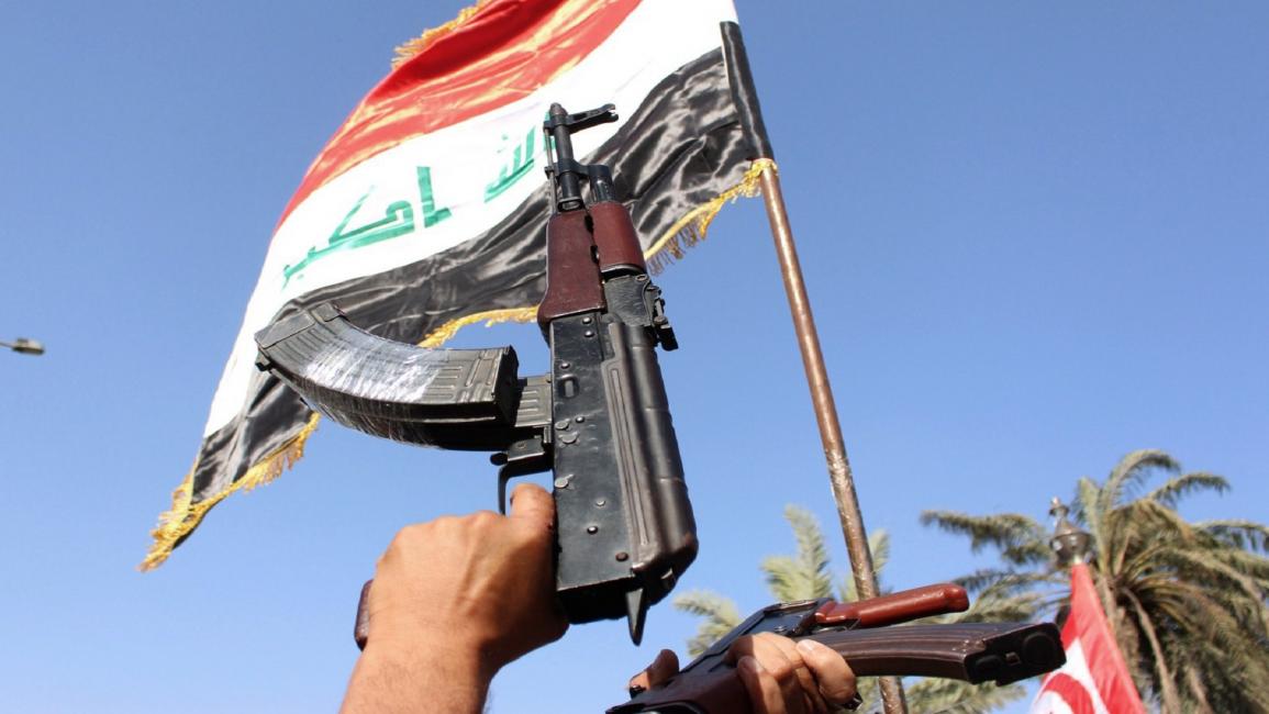 العراق- مجتمع- أسلحة وعلم عراقي- (STR- فرانس برس)