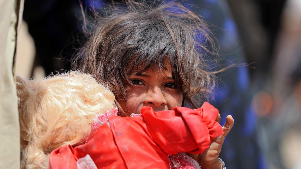 طفلة عراقية نازحة تحمل دمية - العراق - مجتمع