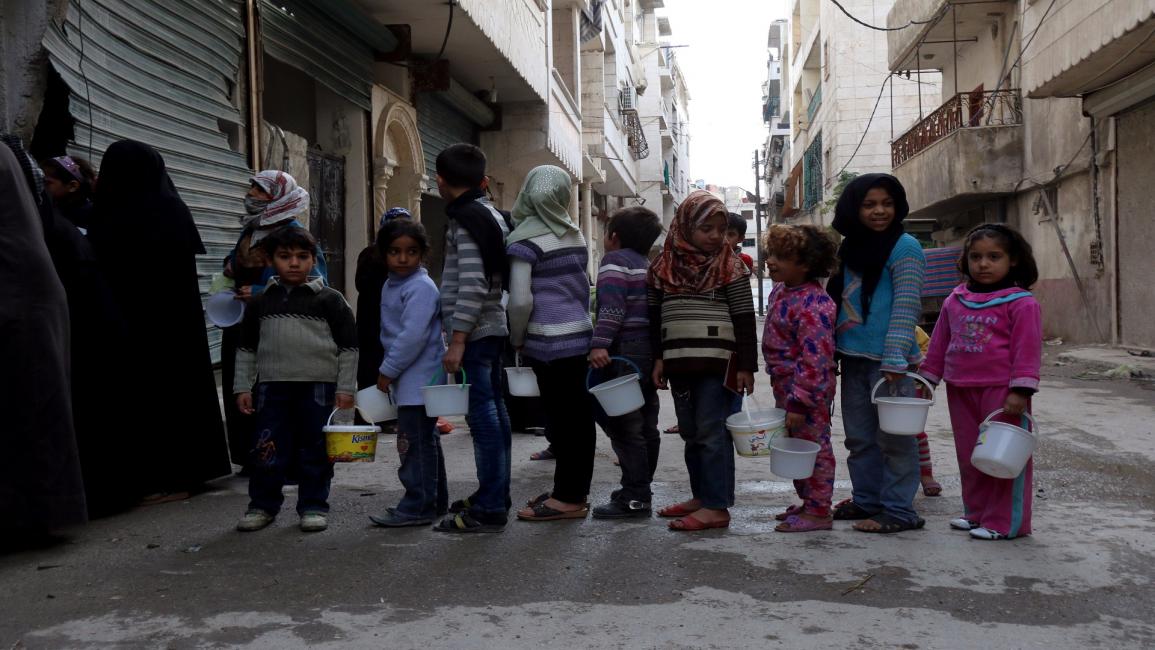 أطفال ينتظرون معونة غذائية في شمال حلب(زين الرفاعي/فرانس برس)